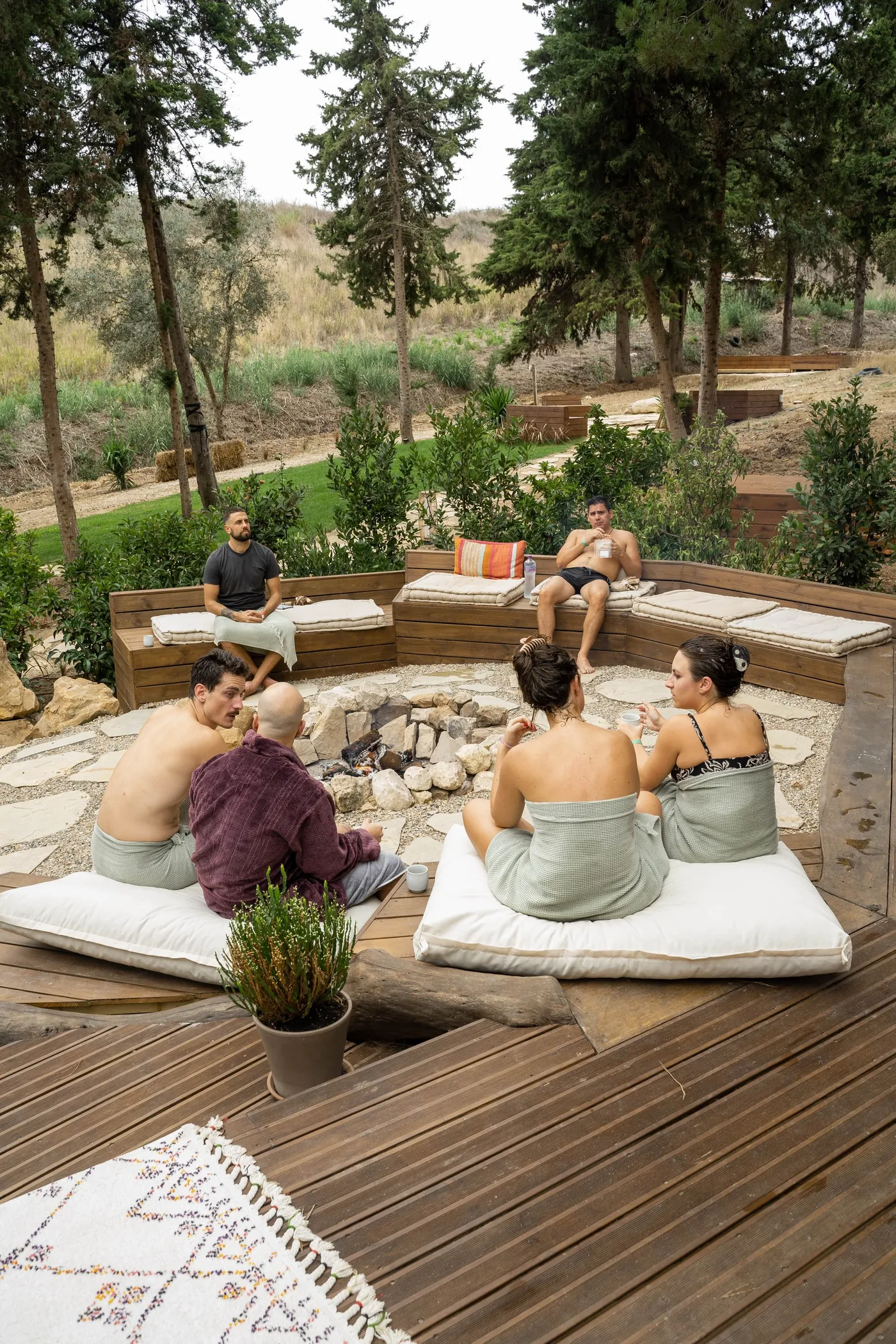 ATMOS guests relaxing and talking around the outdoor firepit at DOMA