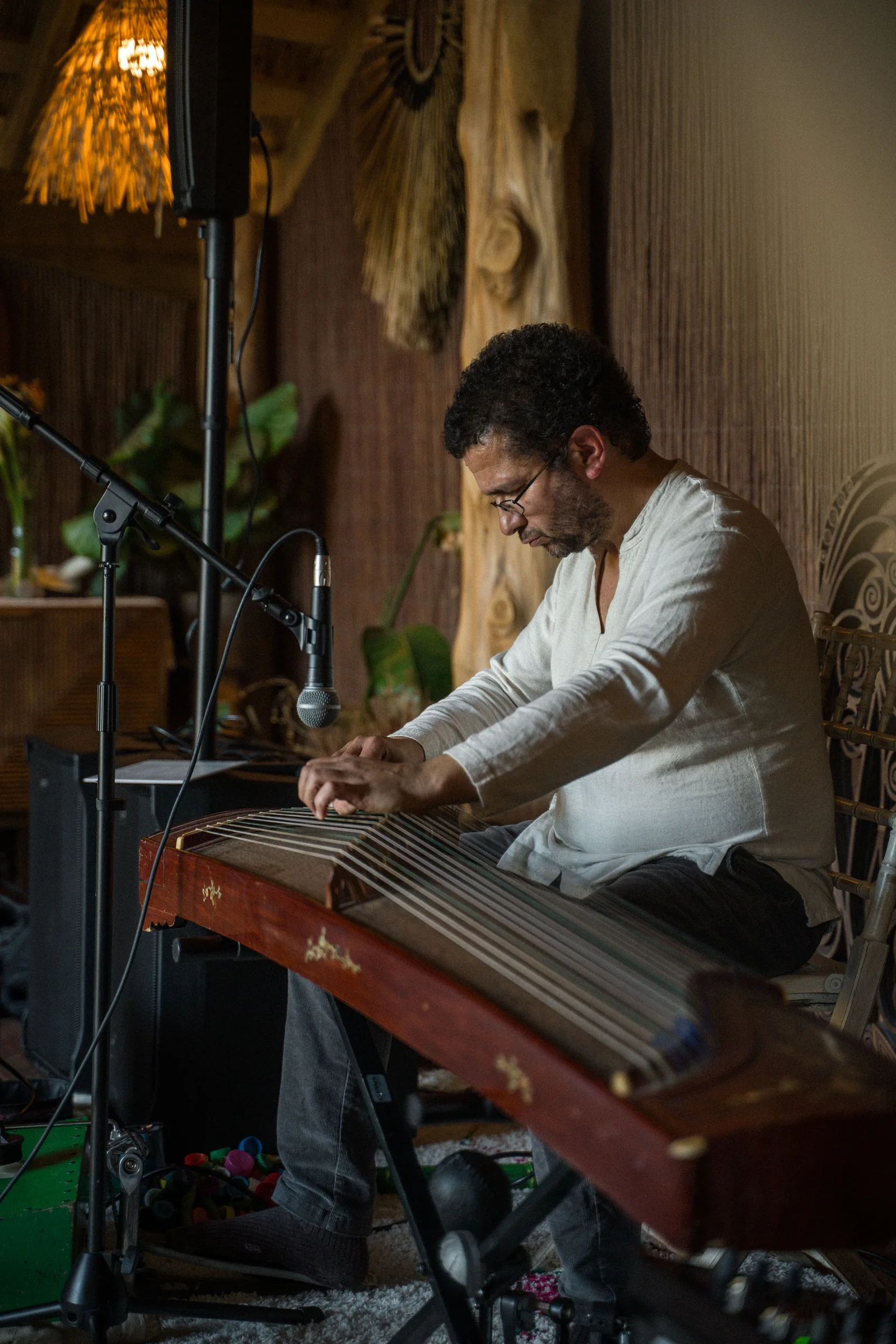 A musician playing a stringed instrument at an ATMOS Sunday Flow gathering