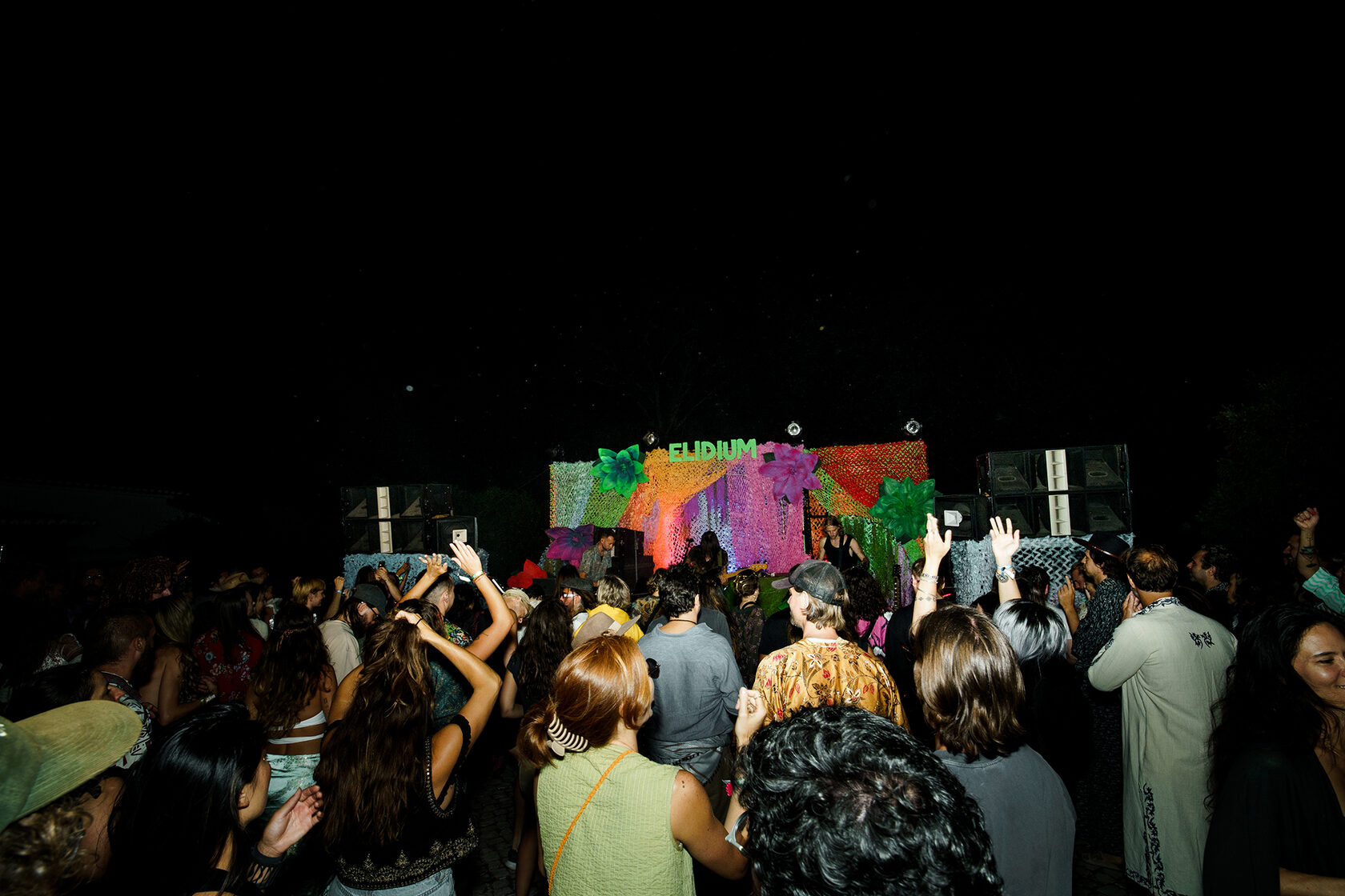 Festival guests dancing in front of the ELIDIUM stage at DOMA after dark