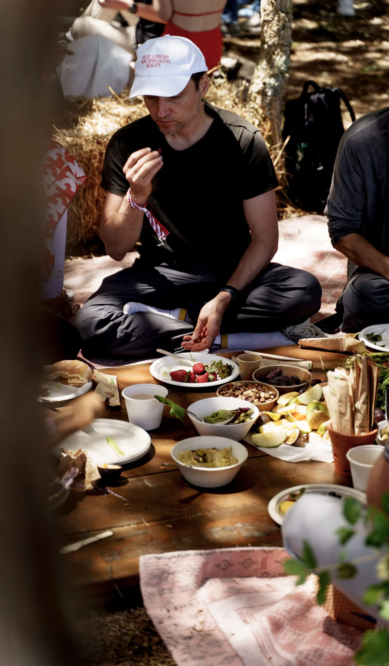 A Founders for Founders guest enjoying food at a shared table in the forest at DOMA